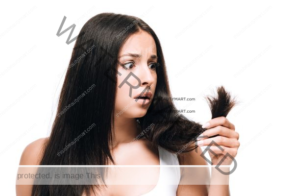 A woman holding her black her in shock of split-ends and hair damage