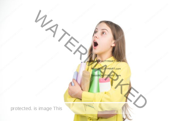 A young woman holding several bottles of hair conditioner and in a state of shock