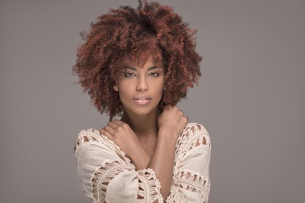 Black woman with curly hair dyed red