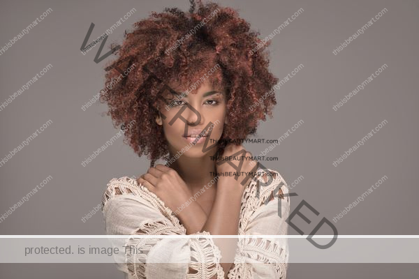 Black woman with curly hair dyed red