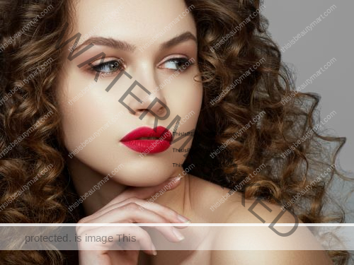 Long curly brown hair on a woman with hot red lipstick and looking sideways