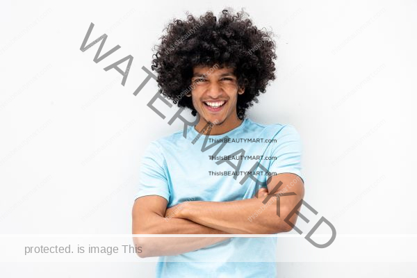 Man of color with thick, curly hair beautifully smiling at the camera