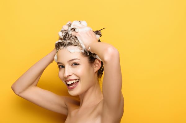 Woman enjoying using shampoo on her hair