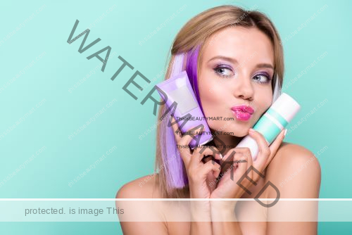 Woman holding two tubes of hair conditioner close to her face