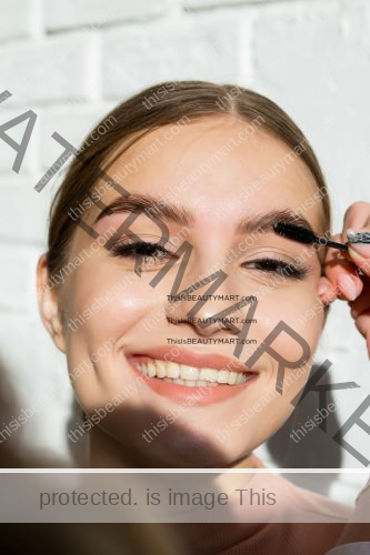 A woman using eyebrow gel to brush and groom her eyebrows